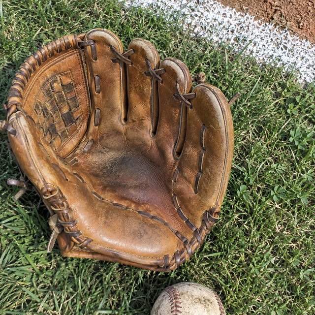 An old fielder's glove on the infield grass