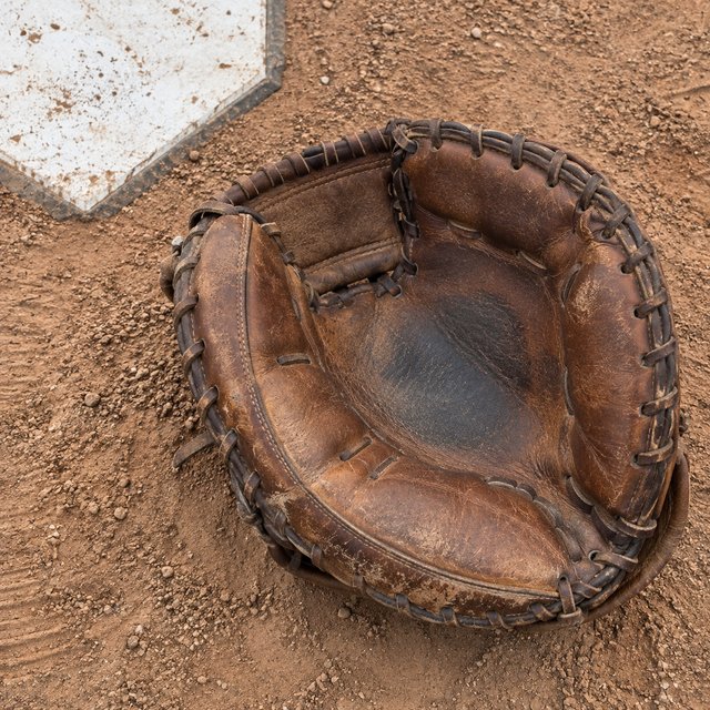 A catcher's mitt on the dirt beside home plate