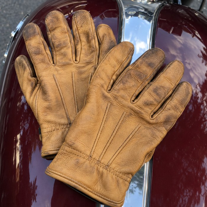 Tan leather riding gloves on a gas tank